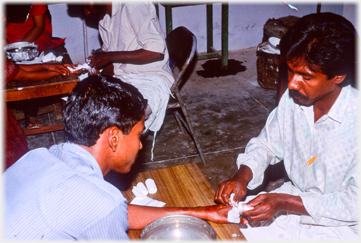 Putting plaster on a patient's hand.