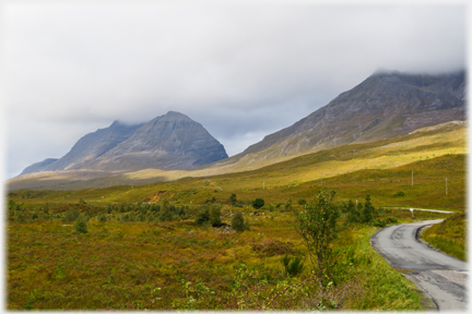 Small road winding towards hill.