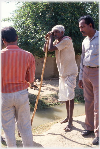 Senior man leaning on staff.