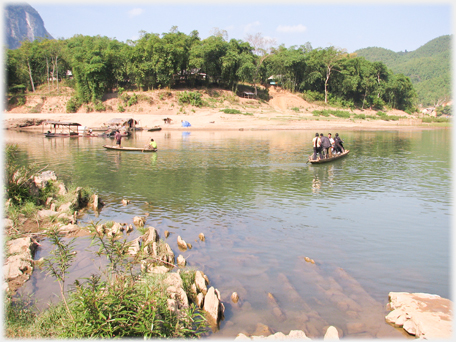 View across river with boats on river and at far shore.