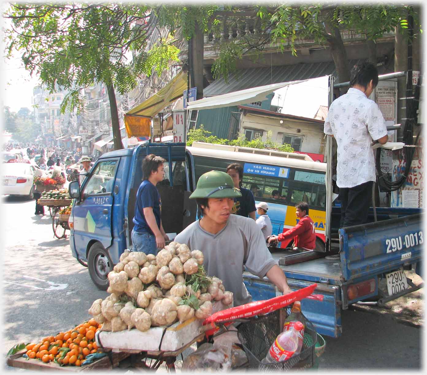 Man wheeling bike laden with fruit and vegetables.