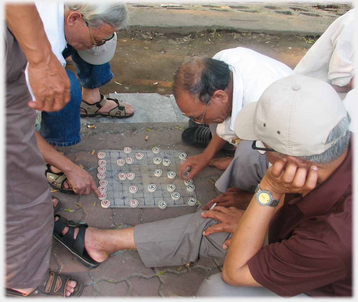 Glassed man moves piece while other touches a piece.