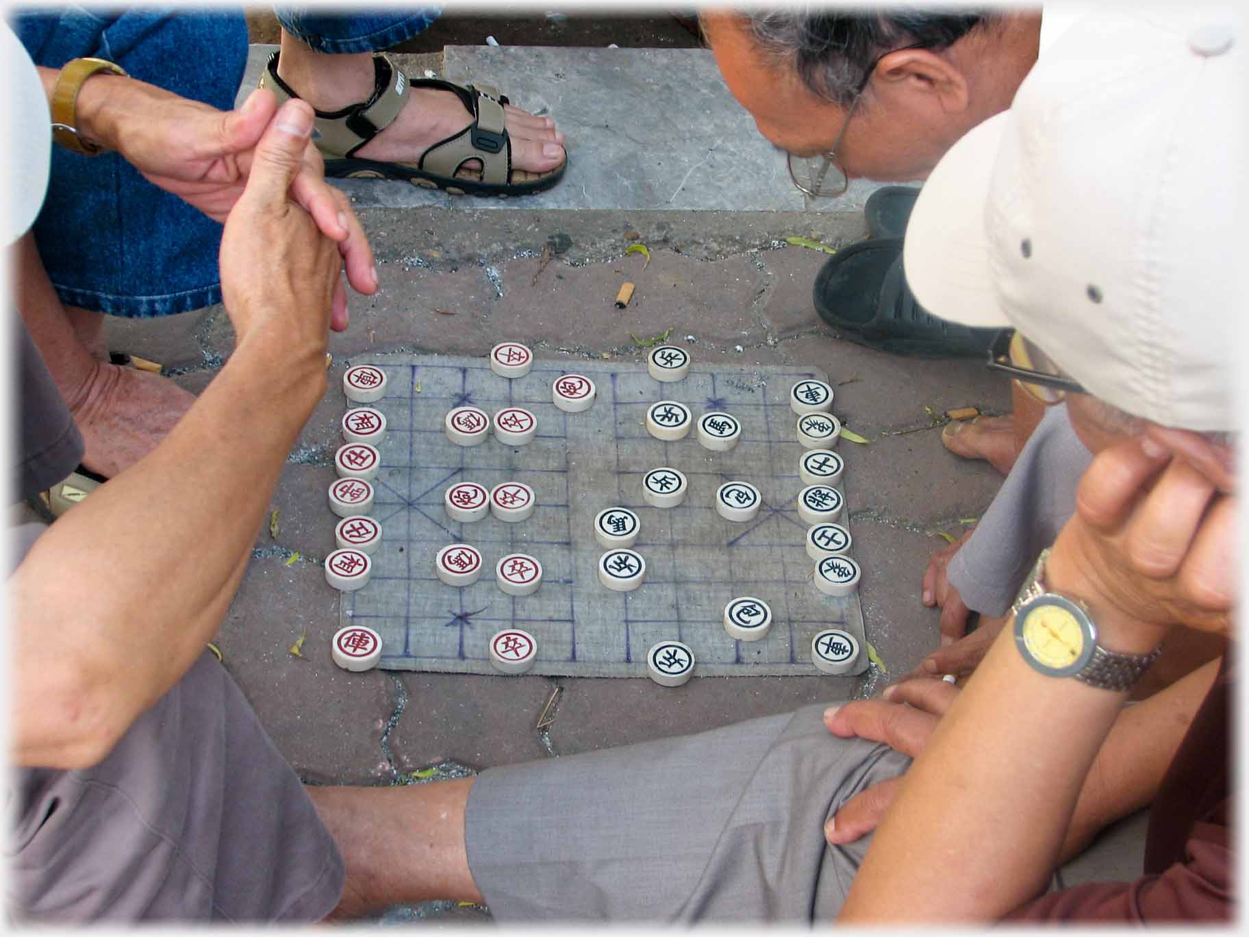 Man with glasses looking very closely down at his pieces.