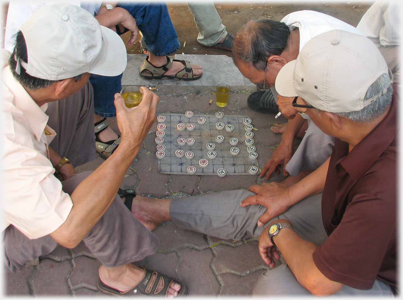 Game in progress wiith tea beside it, and glass in one of the hands.