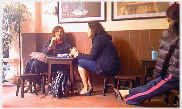 Two western women talking at table in coffee house, side of Viet woman.