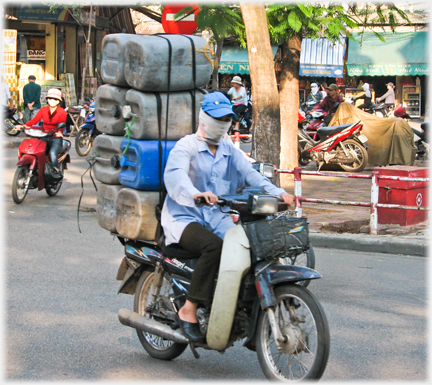 Eight jerrycans behind fully masked woman.