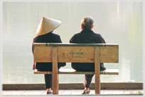 Couple seated with water beyond them.