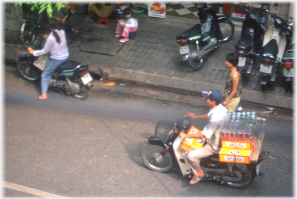 A number of yellow Halida boxes pilled up behind and between legs of driver.