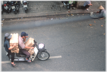 Woman holding bundles - just on pillion seat!