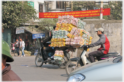 Bike with enormous pile of coloured packets.