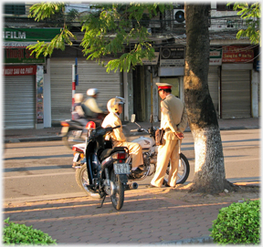 Two traffic policemen talking together at road side.