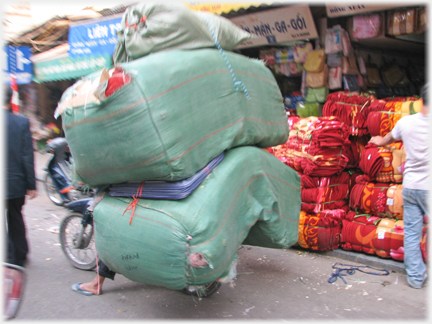 Two huge sacks, with a foot protruding from bottom corner.