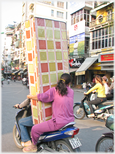 Woman pillion holding bed - closer.