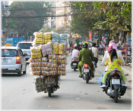 Bike piled very high with coloured packets.