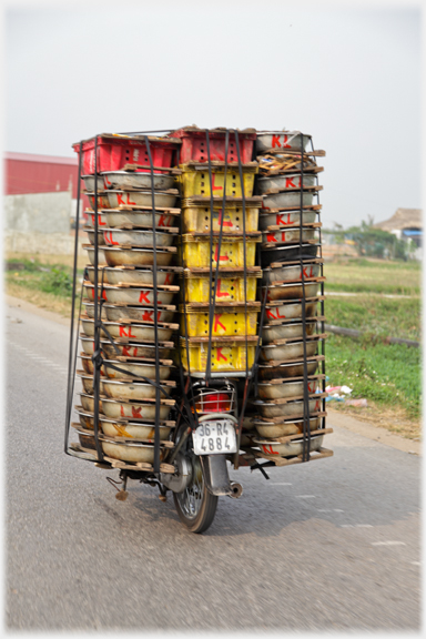 Stacked flat boxes numbering over 70 seen from rear of moving bike.