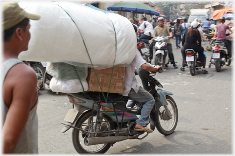 Large white bundle on top of boxes above driver's head.