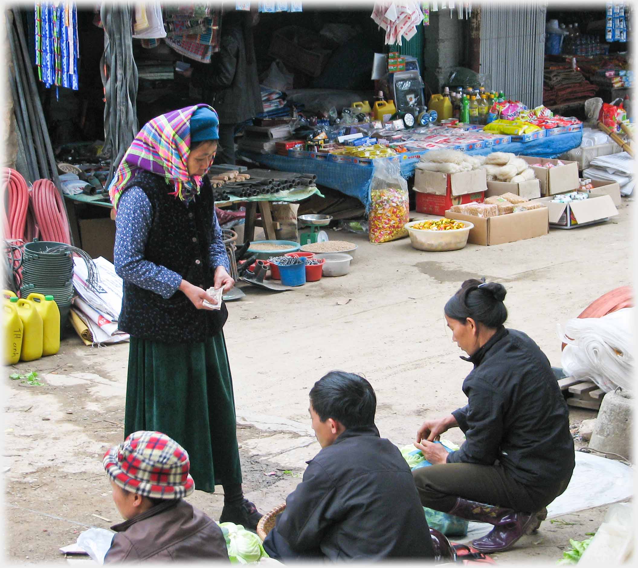 Woman holding money as vendor ties plastic bag.