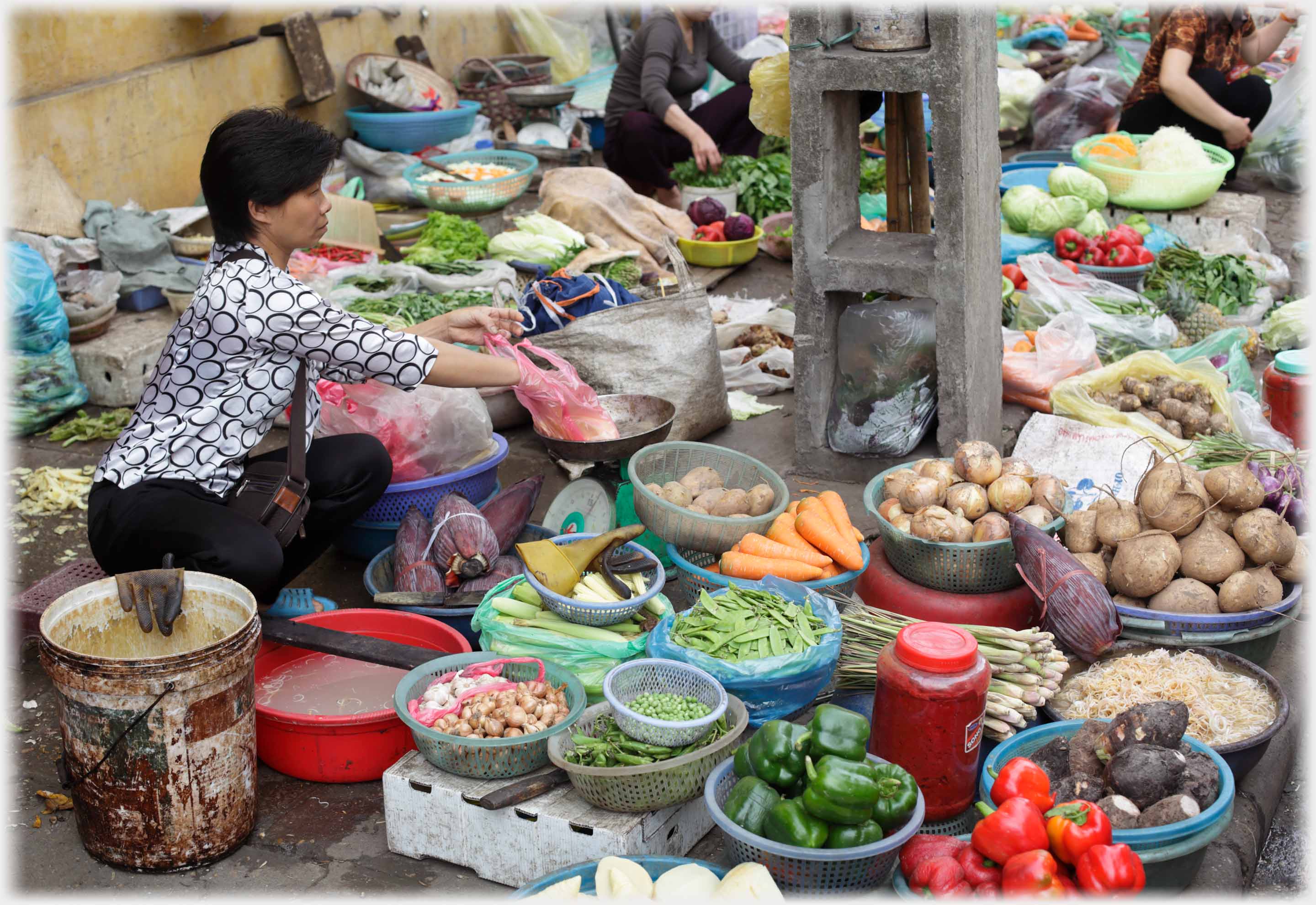 Woman with many bowls of sifferent vegetables arranged in front of her.