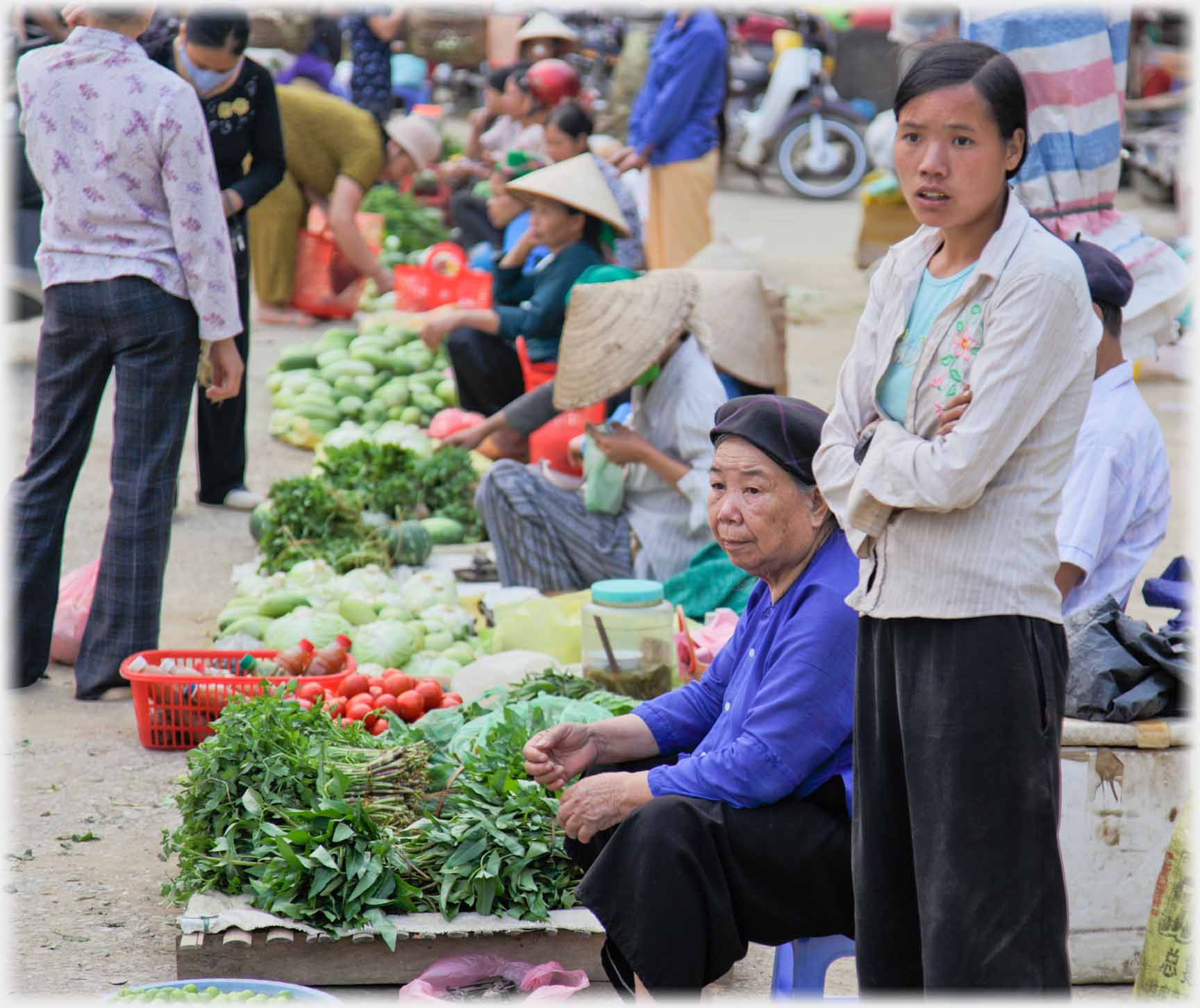 Younger woman standing by sitting older woman both, in their different ways, with expressions of anxiety at what they are staring at.