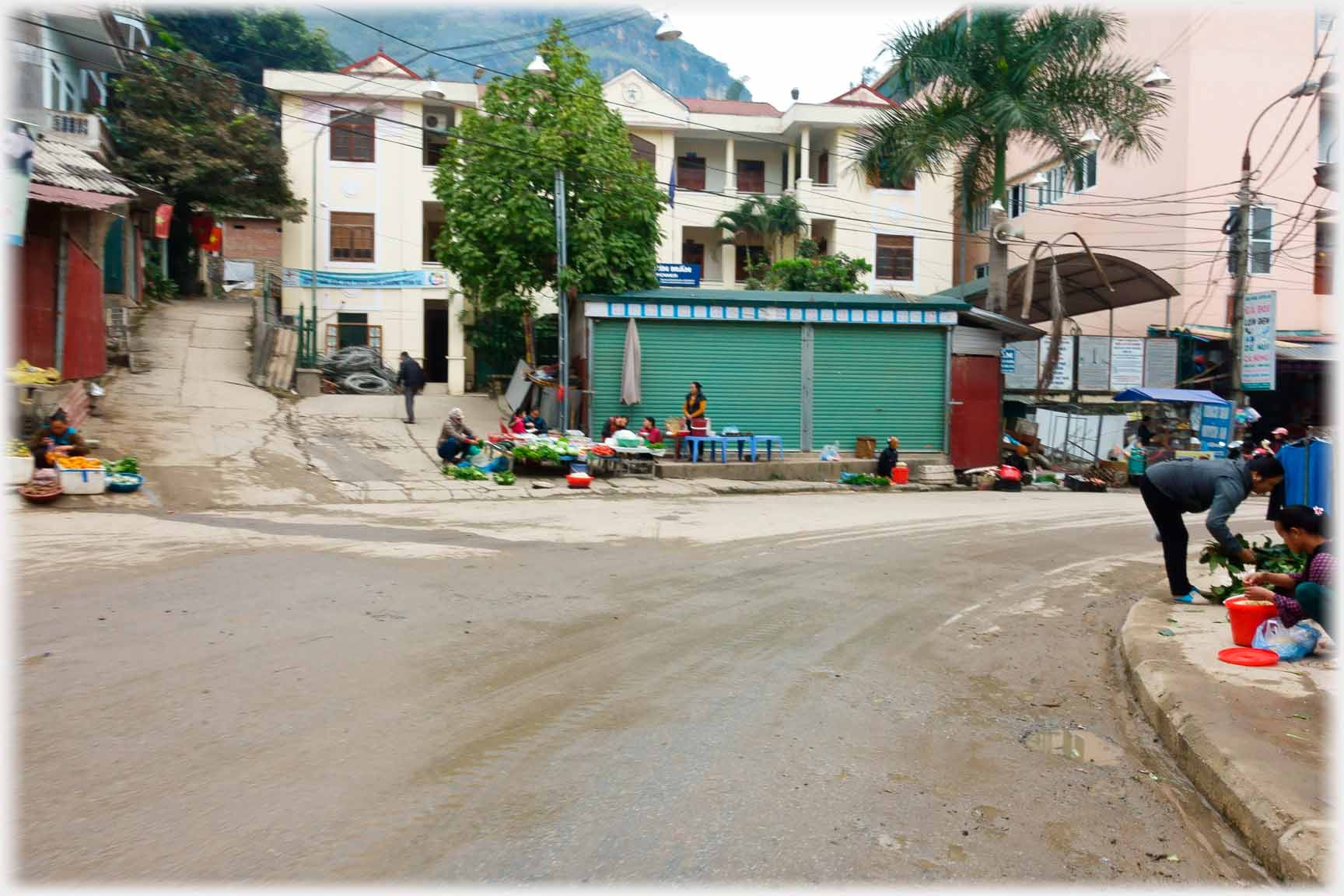 Bend and road junction with stalls at intersection.