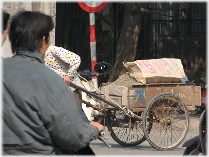 Cart beng pulled, but head of puller obscured.