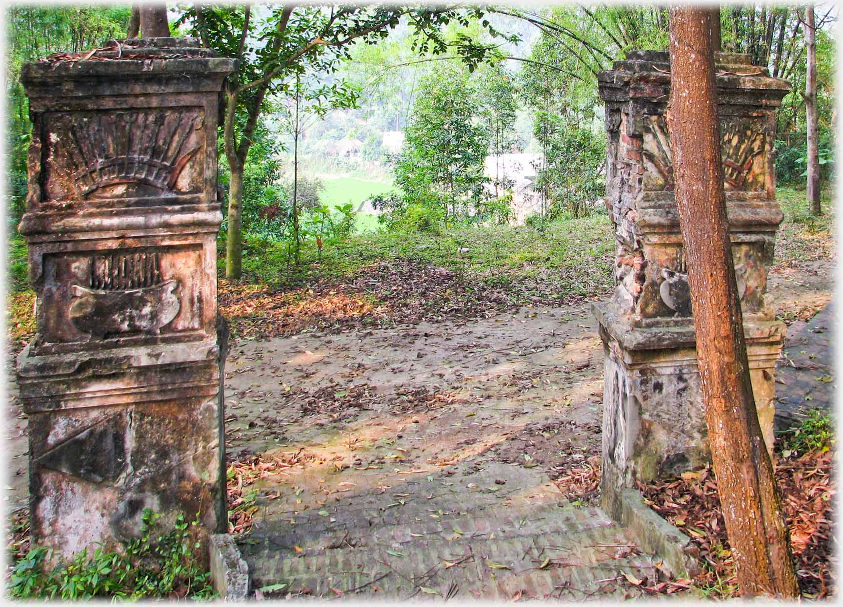 Two ornimental gateposts alone in the woods.