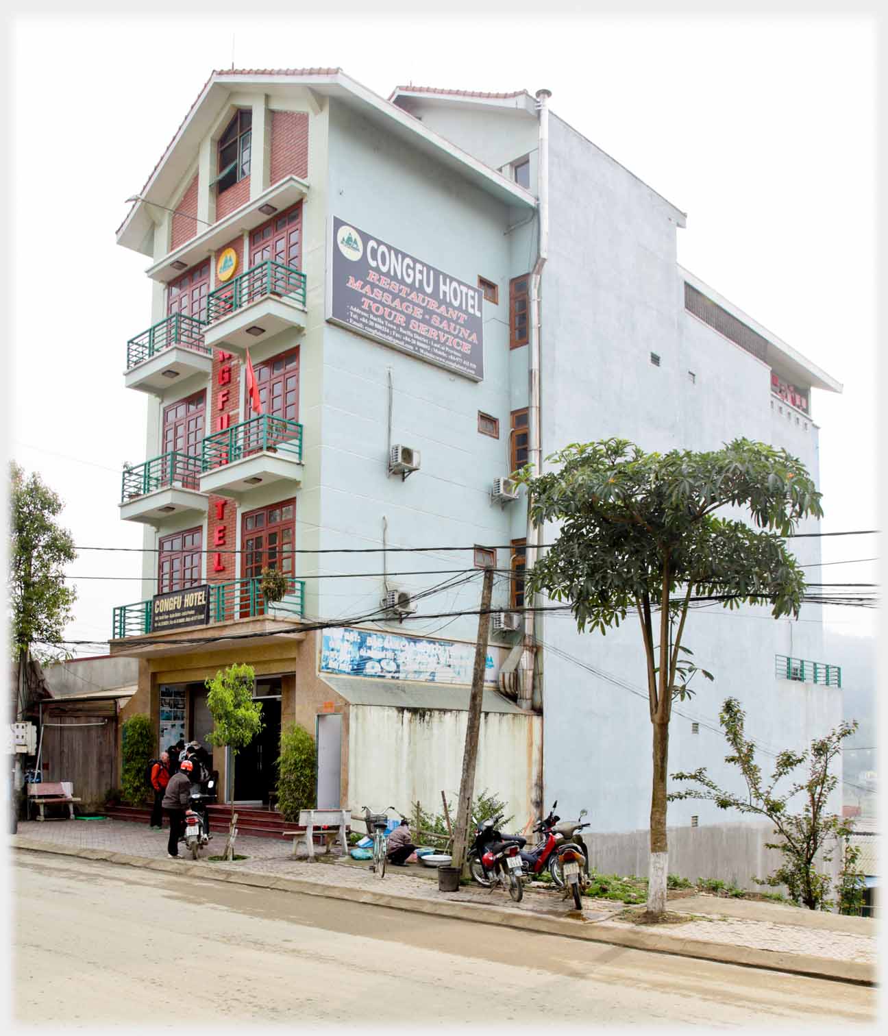Five story hotel with balconies for each of two rooms on each floor, big signs on walls.