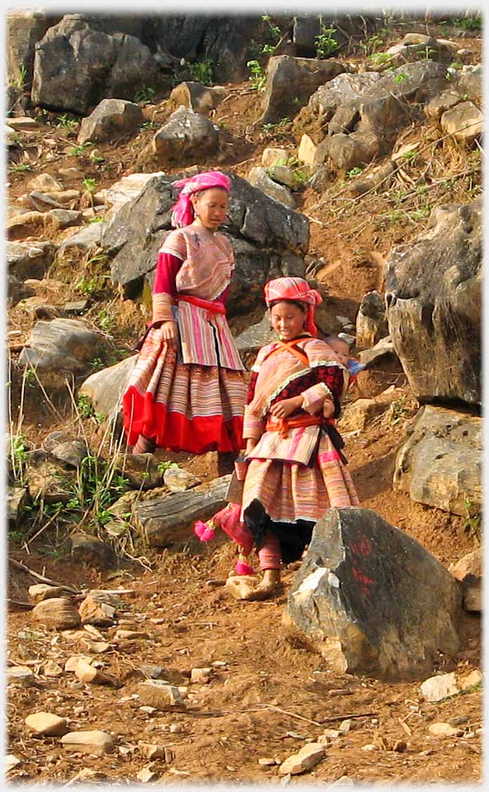 Two women coming down a rocky hillside.