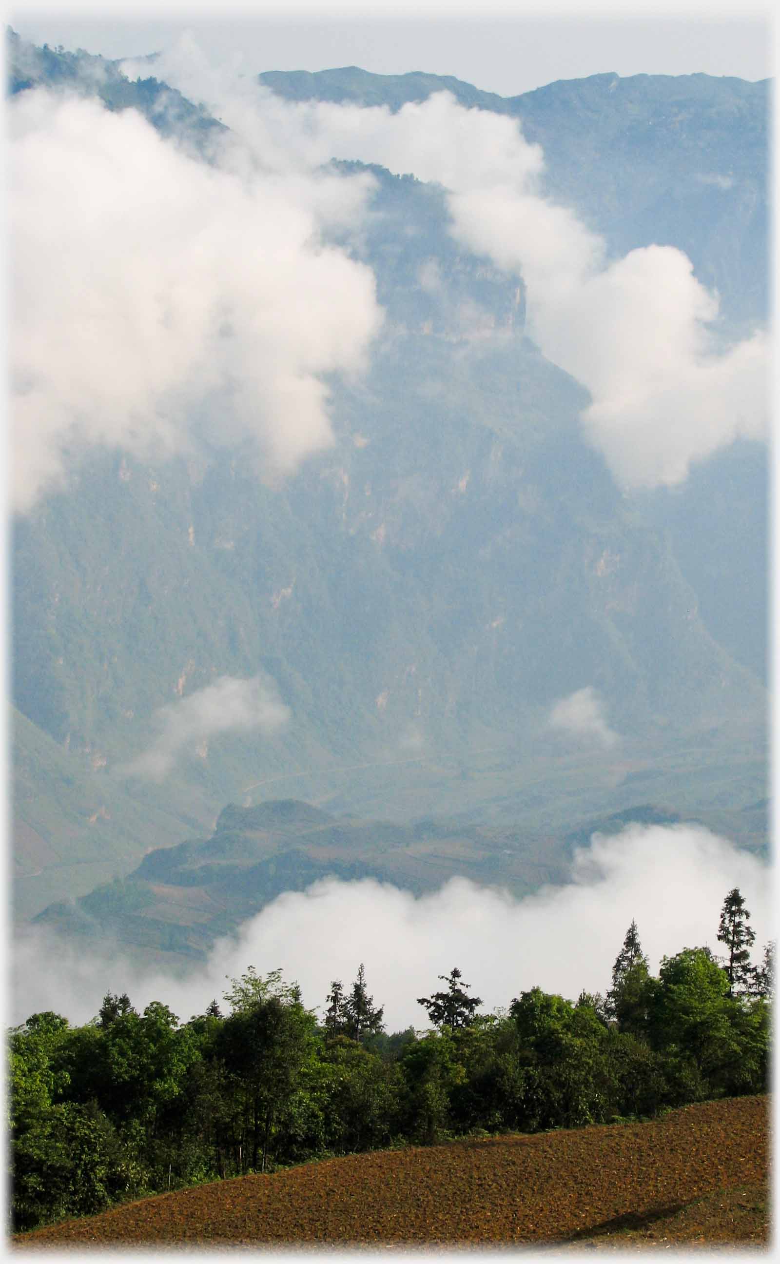 Mist clinging to high vertical hillside.