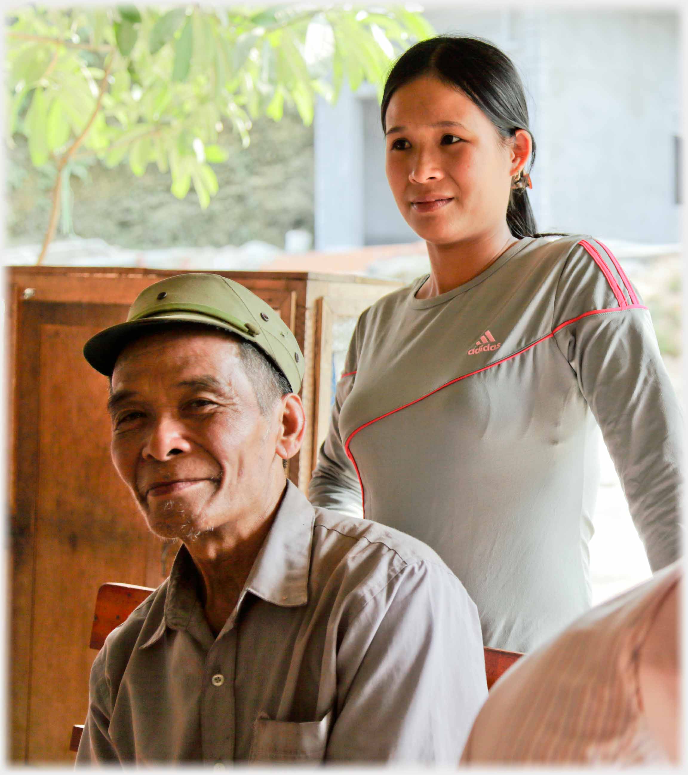 Man sitting, woman standing behind.