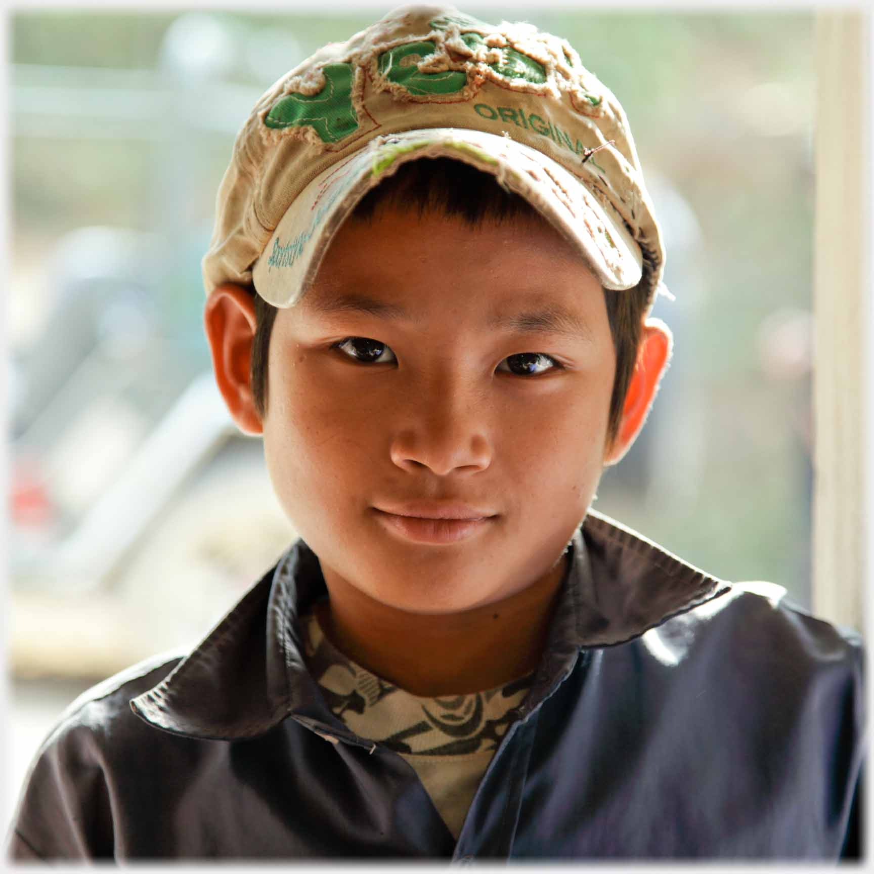 Boy gently smiling face square on.