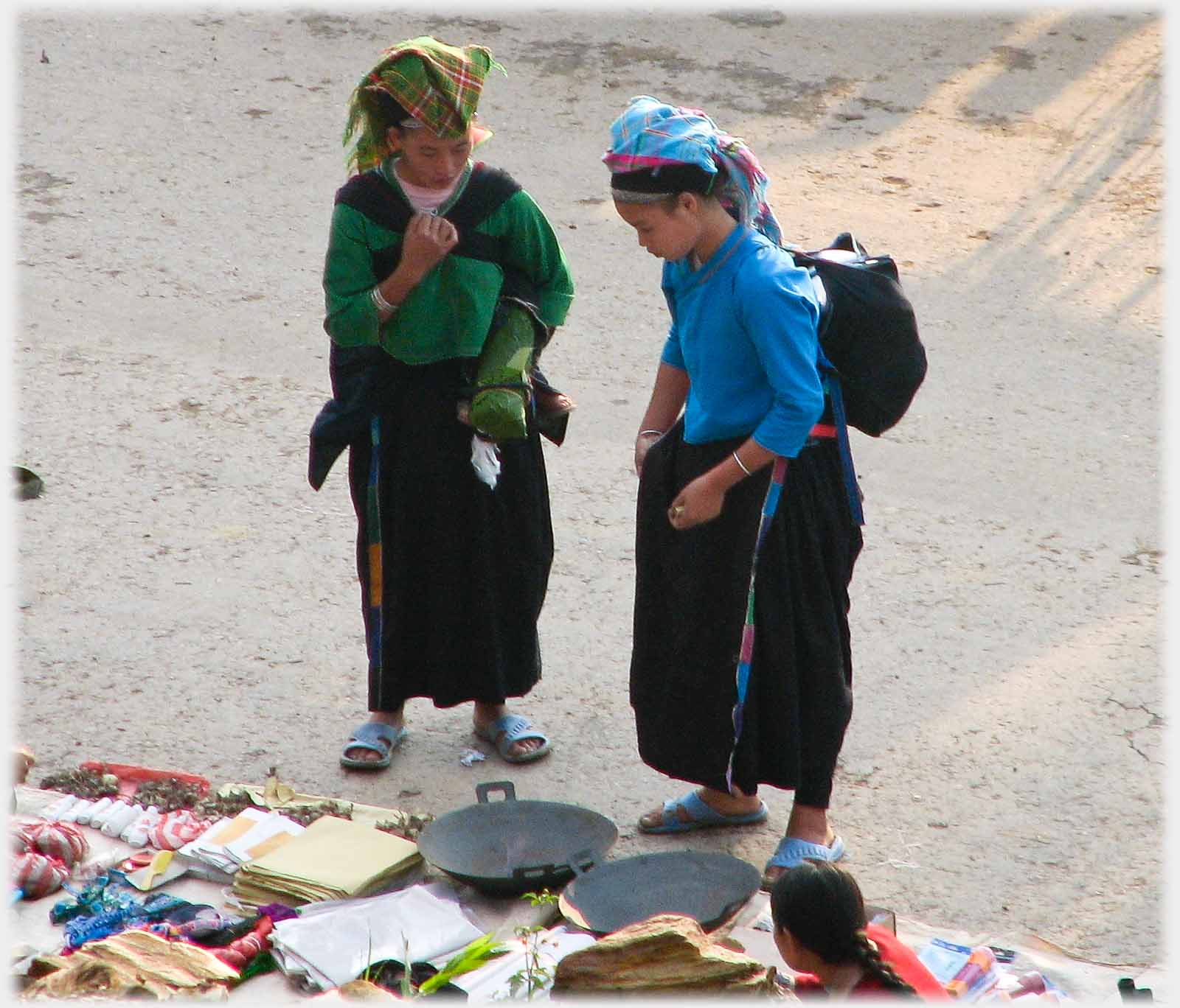 Two women, one searching pocket, other looking hopeful.
