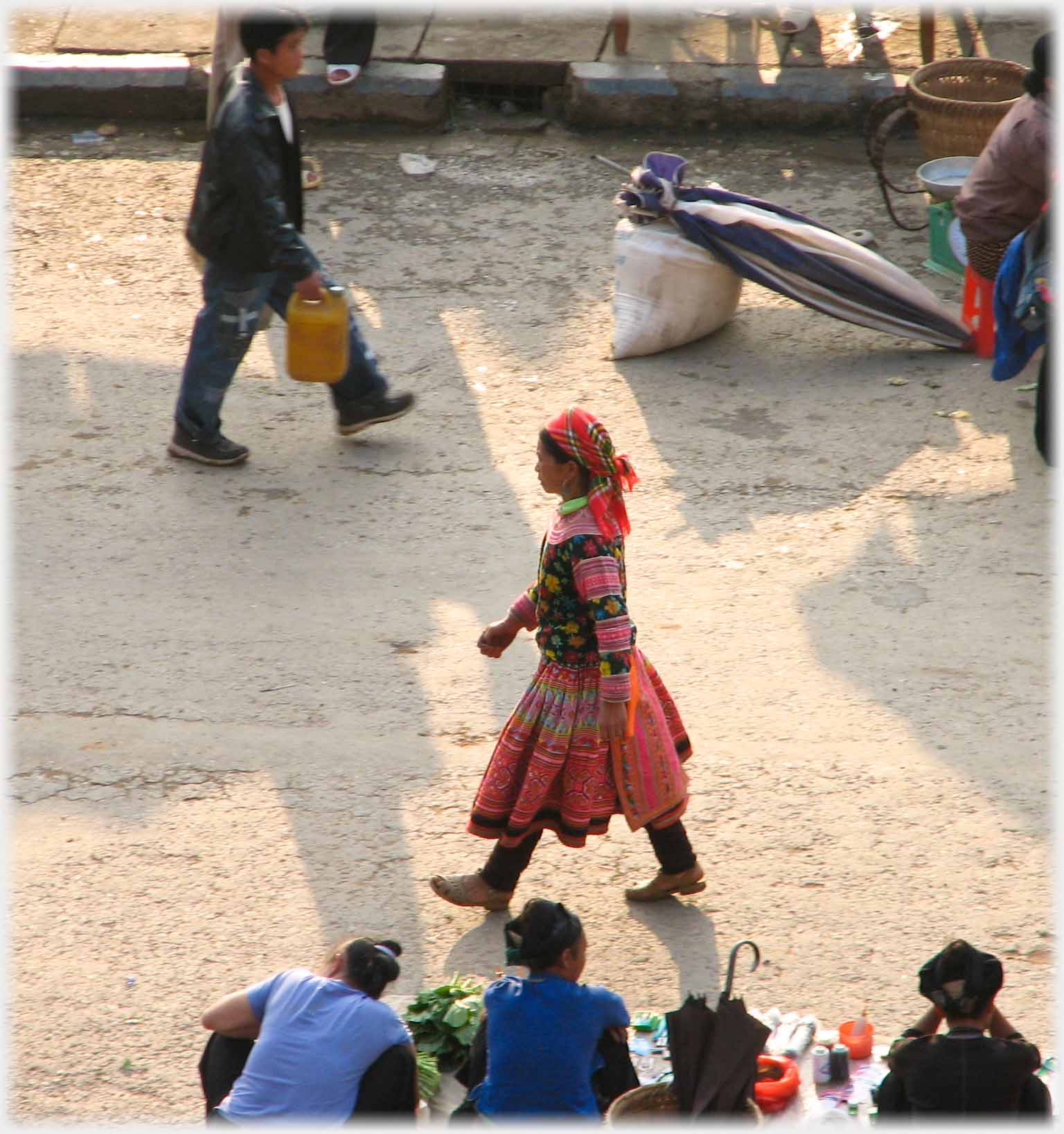H'mong woman walking purposefully past.