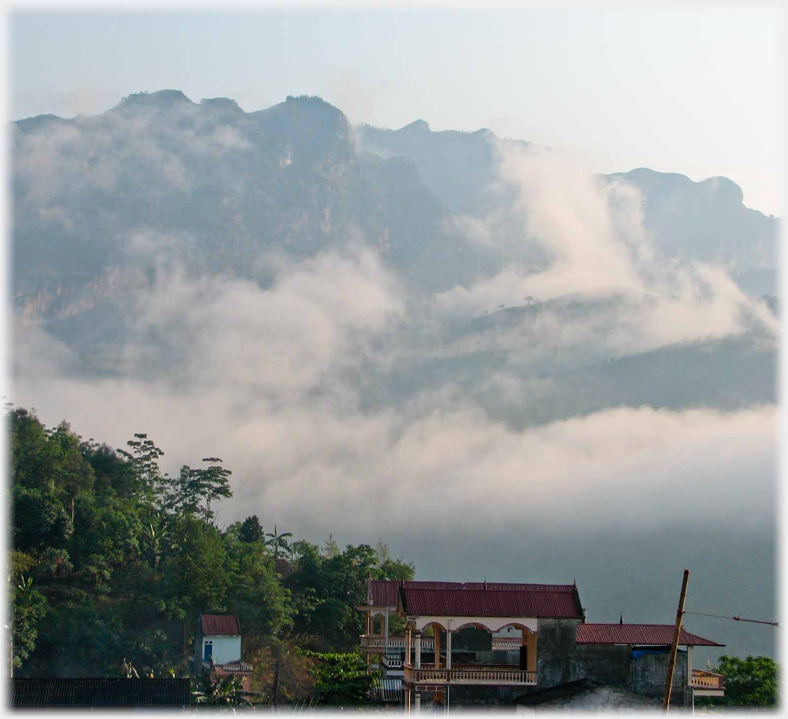 Hill face with various shaped clouds on it.