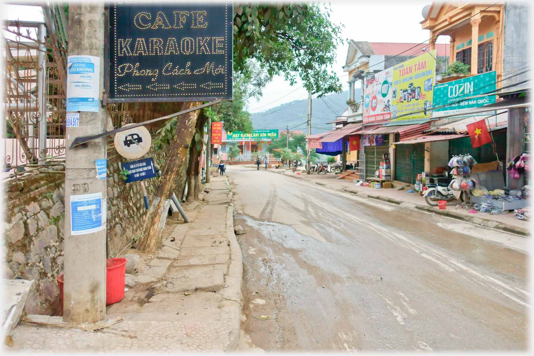 Looking down a road with Karaoke sign on post.