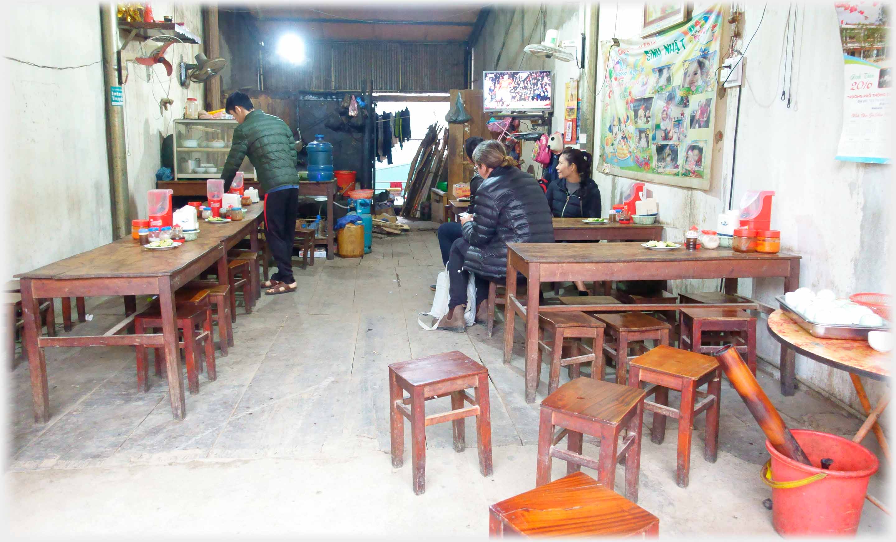 Interior of cafe with tables and stools.