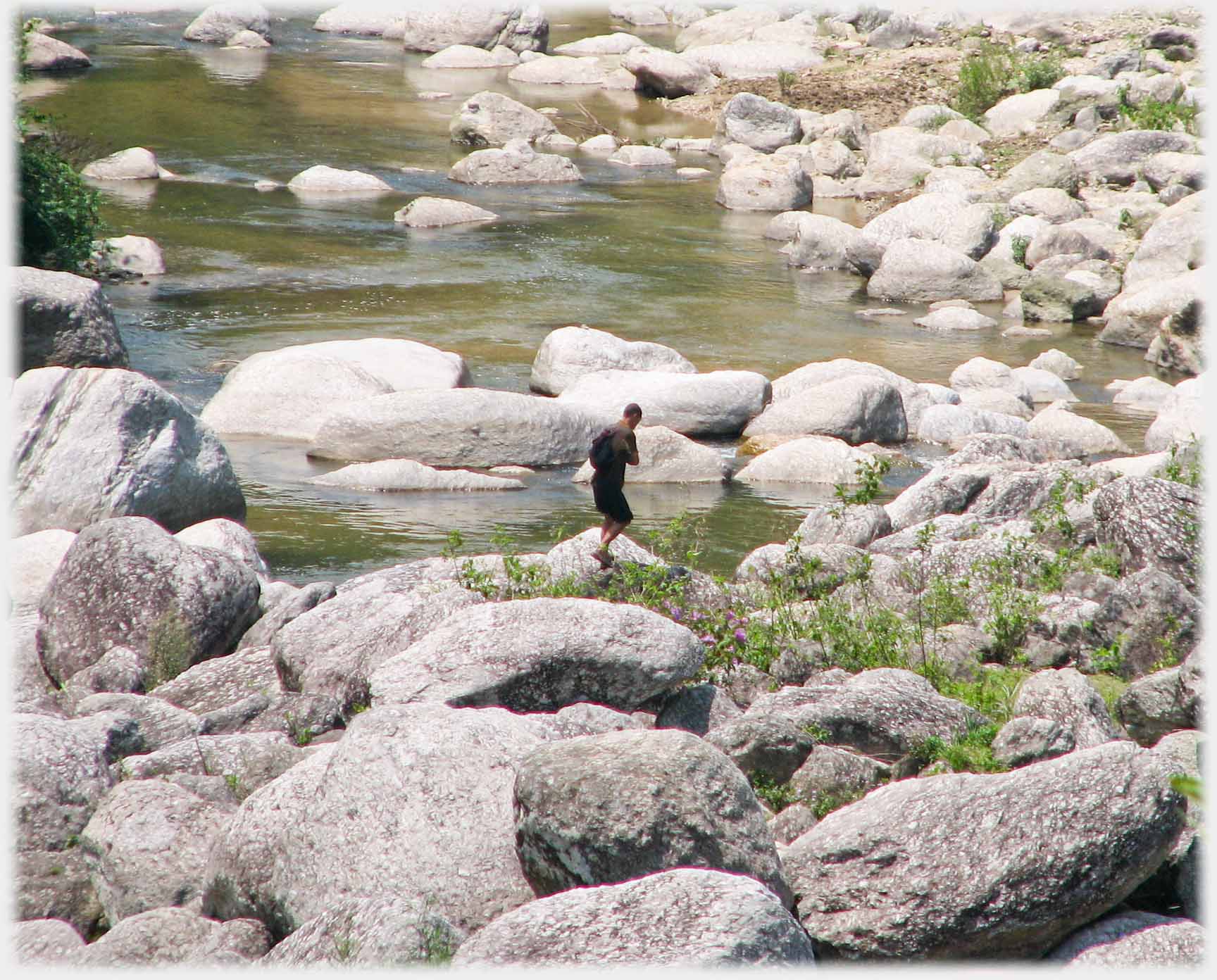Figure among boulders larger than it.