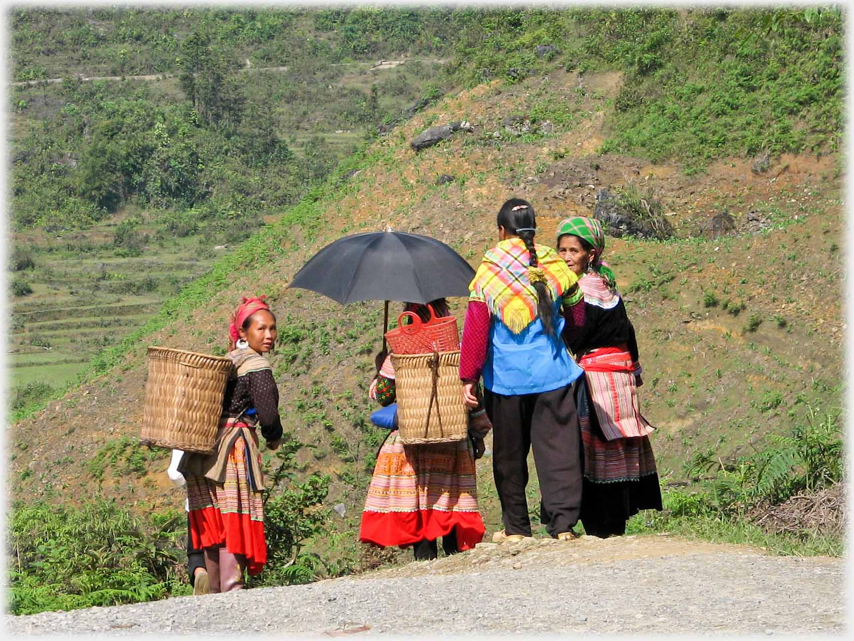 Four women walking away from camera, two turning to look back.