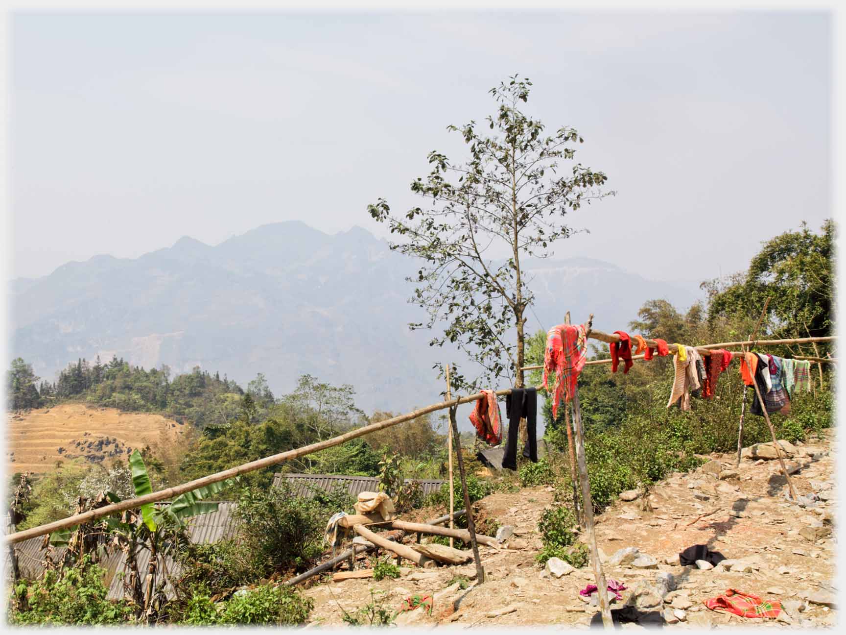 Horizontal bamboo poles some with washing on them