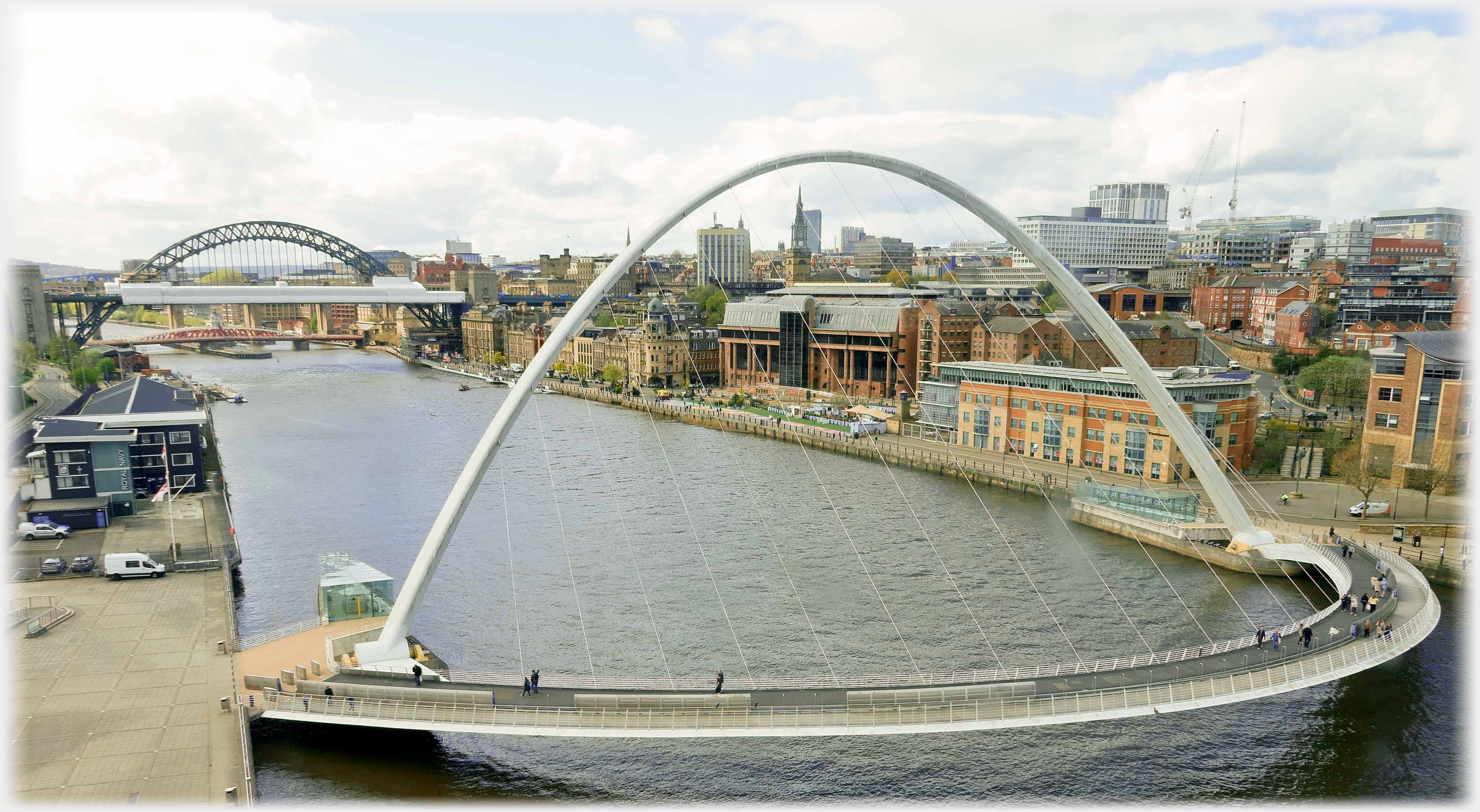 High arched foot bridge over river.